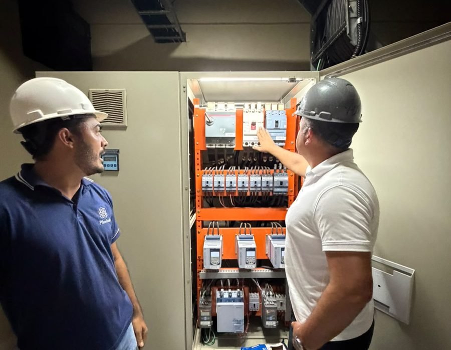 Profissionais analisando painel elétrico em obra